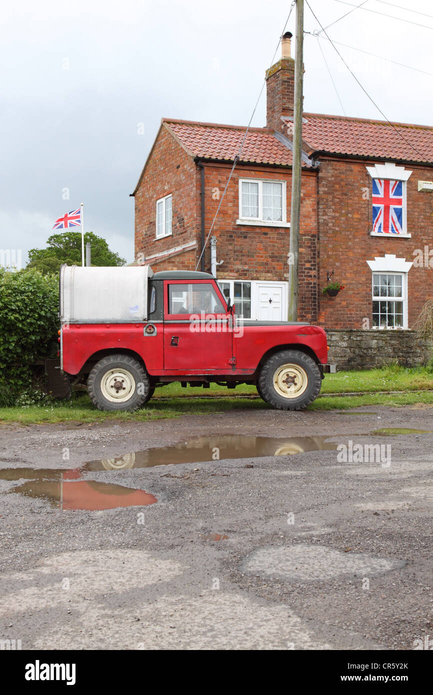 Land Rover Fahrzeug geparkt vor Haus mit britischen Union Jack-Flaggen  Stockfotografie - Alamy