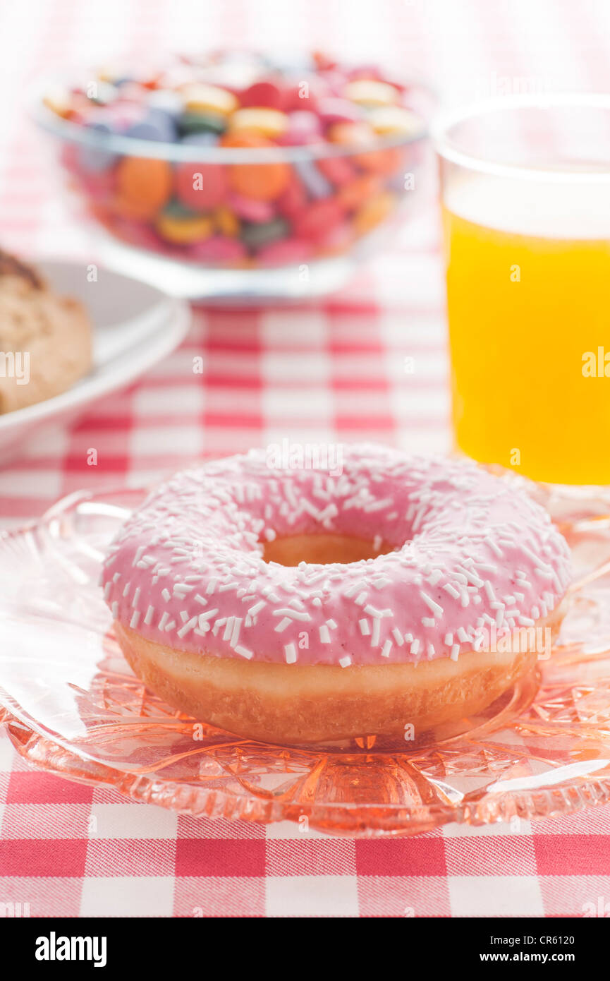 Donut mit Streuseln und einem Glas Orangenlimonade Stockfoto