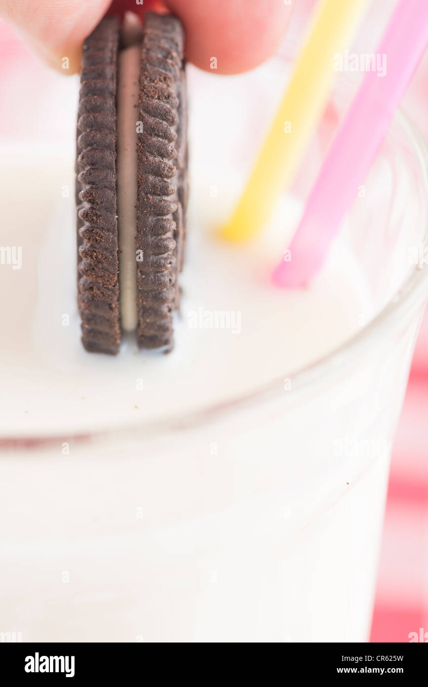 Eine Schoko-Cookie in ein Glas Milch Eintunken Stockfoto