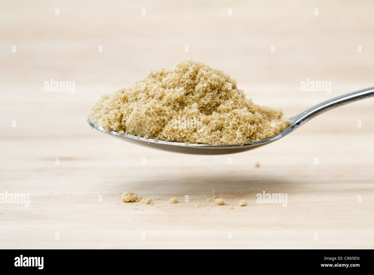 Gehäufte EL brauner Zucker statt über ein Schneidbrett aus Holz Stockfoto