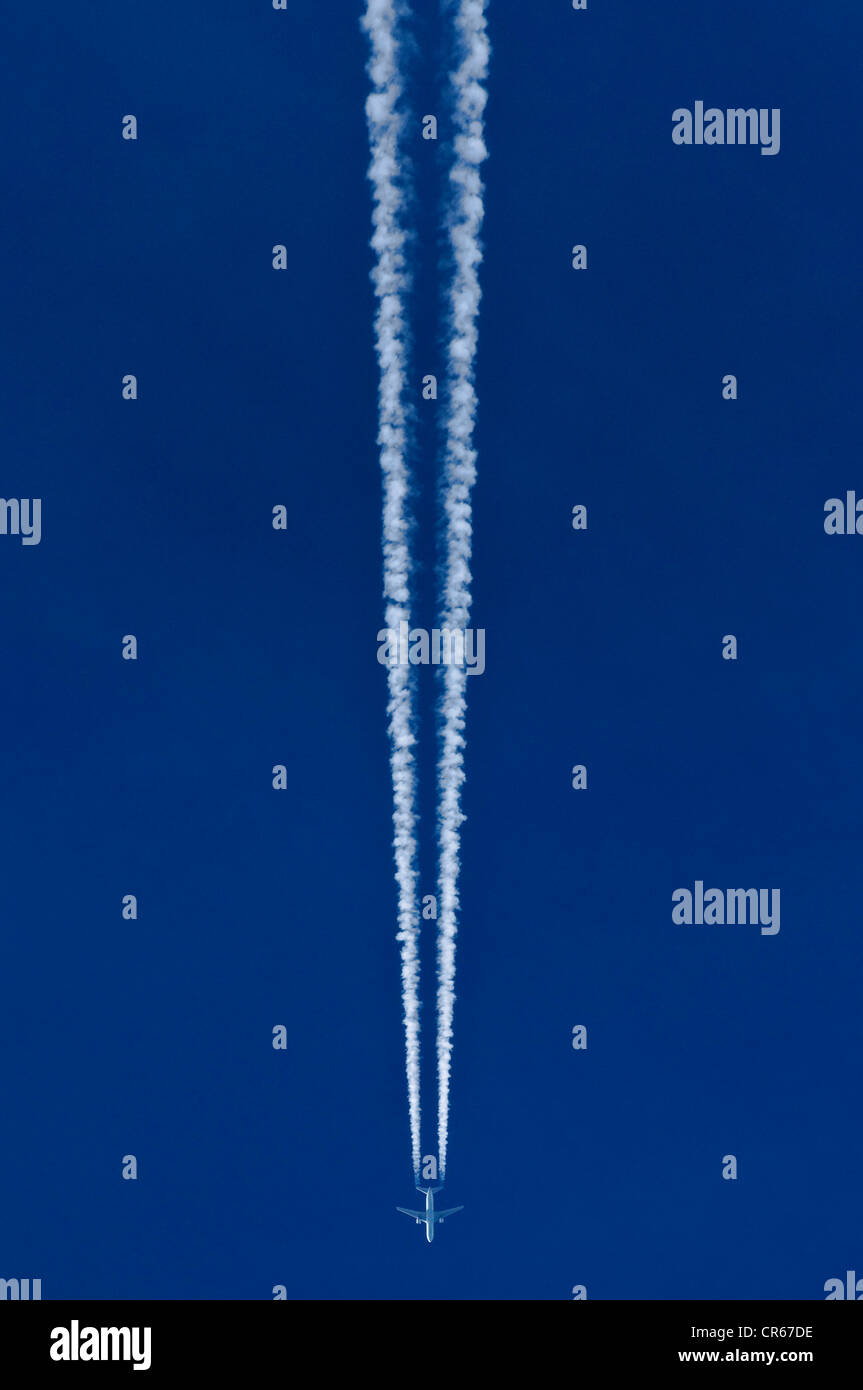 Flugzeuge mit zwei Kondensstreifen vor blauem Himmel Stockfoto