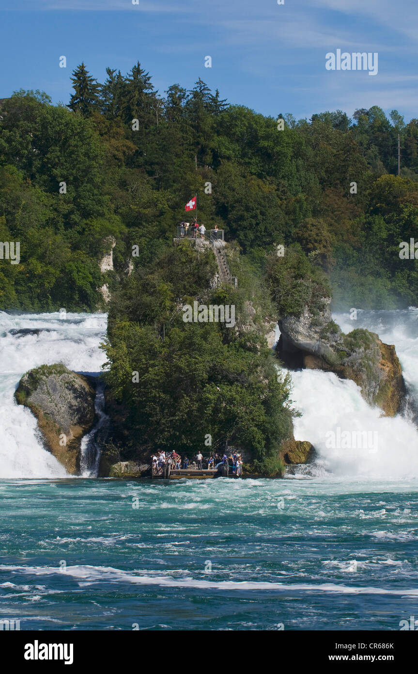 Rock in den tosenden Wassern des Rheins fällt Schaffhausen, Touristen an der Pier und oben auf dem Felsen, Schweiz Stockfoto