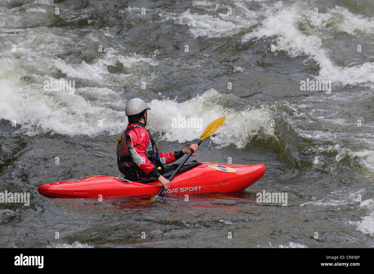 Wildwasser-Kajakfahrer manövrieren durch die Stromschnellen Stockfoto