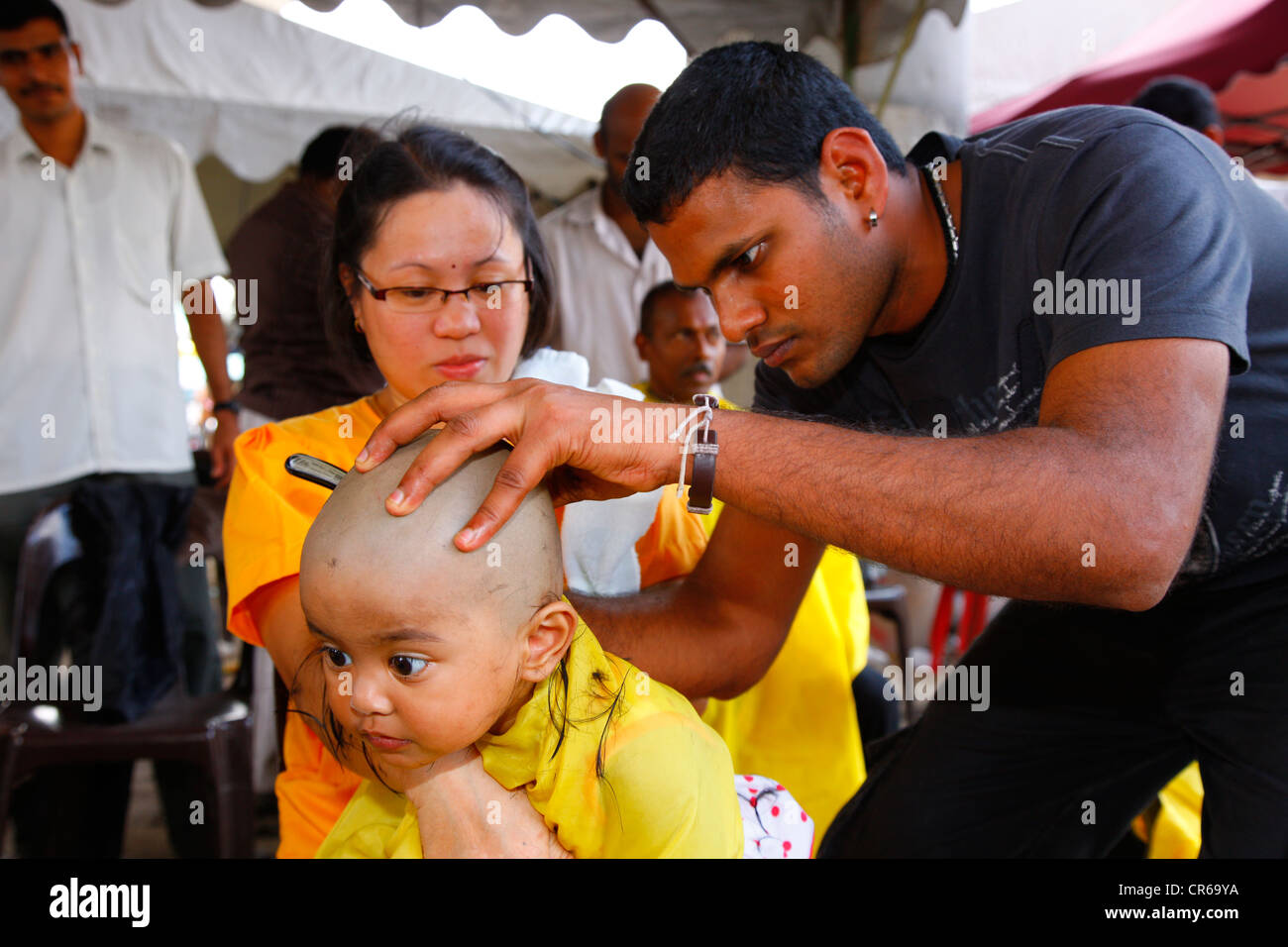 Kind die Haare rasiert werden mit einem Rasiermesser, hinduistische Festival Thaipusam, Batu Caves-Kalkstein-Höhlen und Tempel, Kuala Lumpur, Malaysia Stockfoto