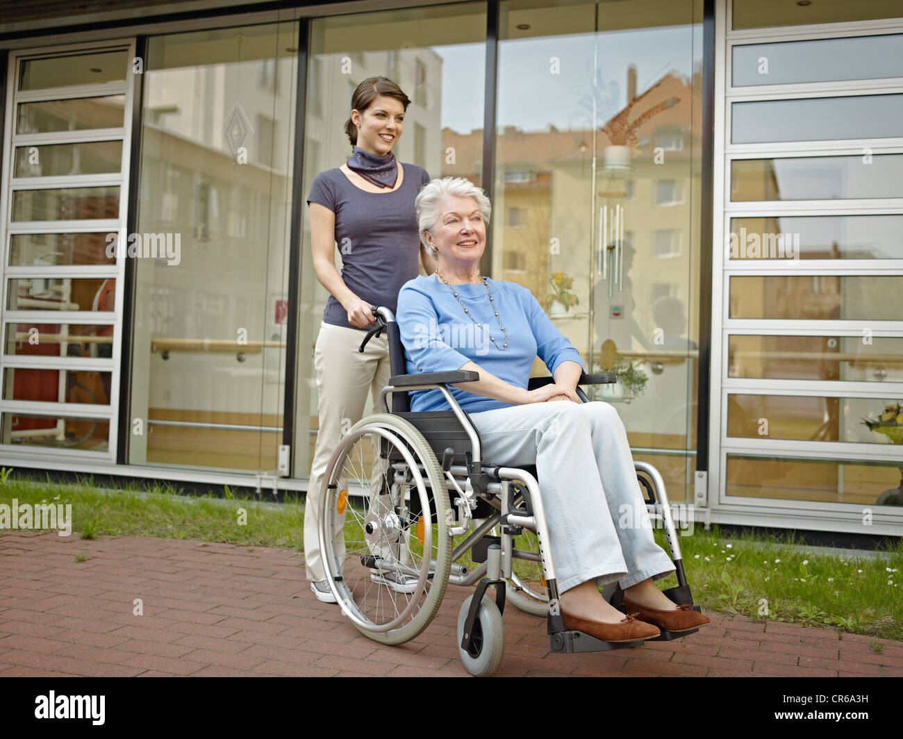 Deutschland, Köln, Frauen drängen Frauen in Führungspositionen im Rollstuhl außerhalb Pflegeheim Stockfoto