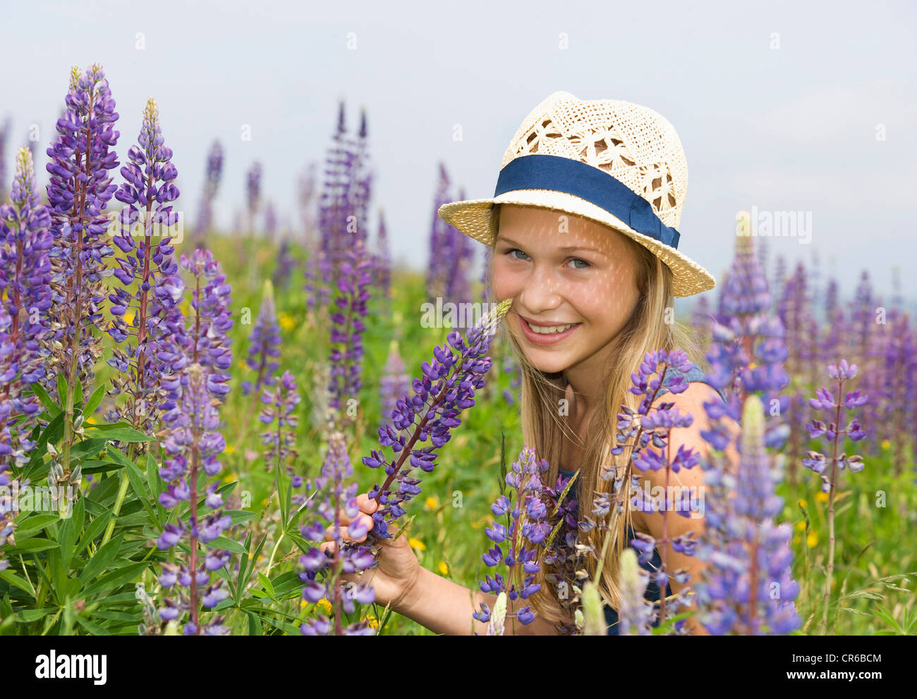 Österreich, Teenage Mädchen halten lupine Blüte, Lächeln, Porträt Stockfoto