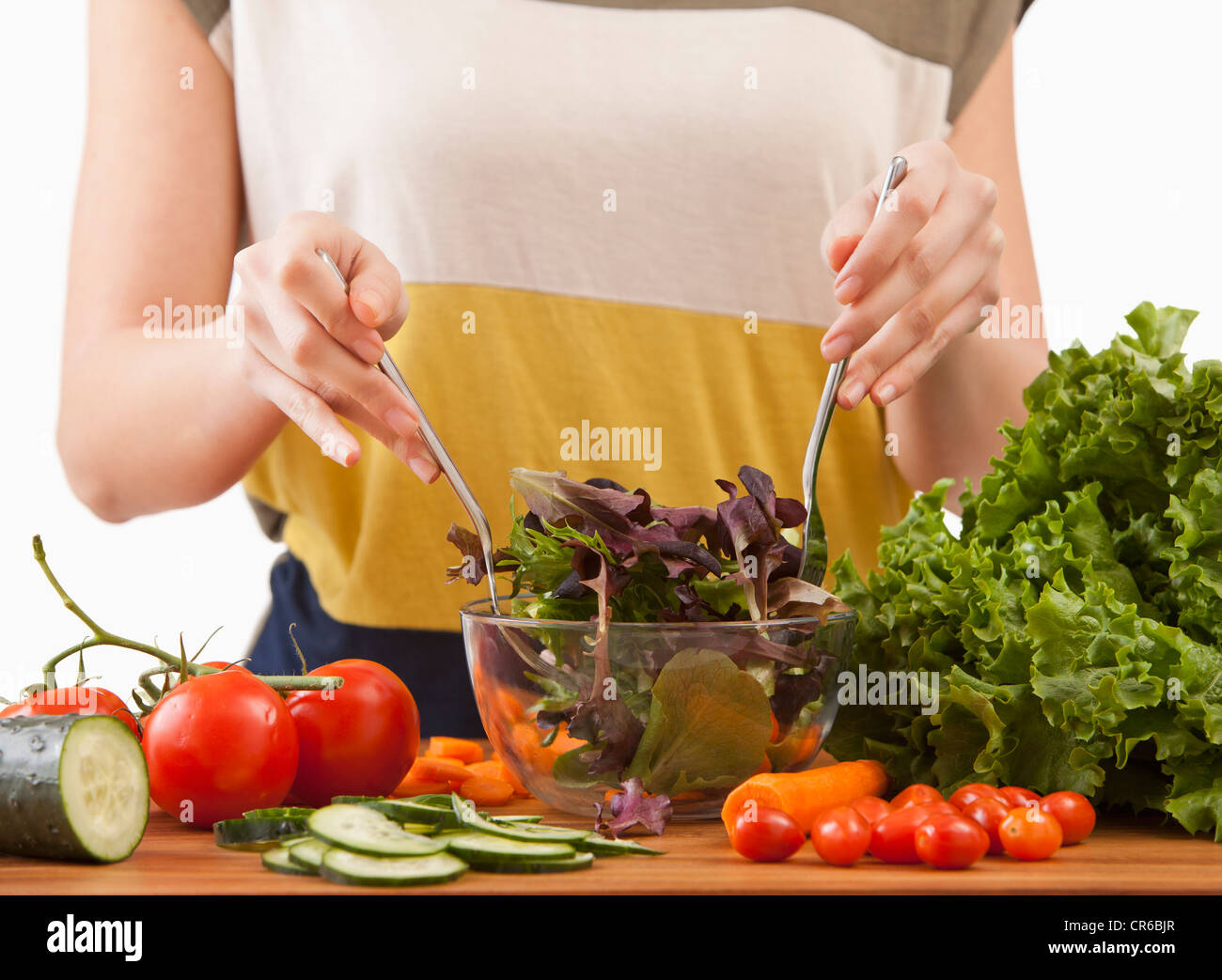 Junge Frau bereitet Salat Stockfoto