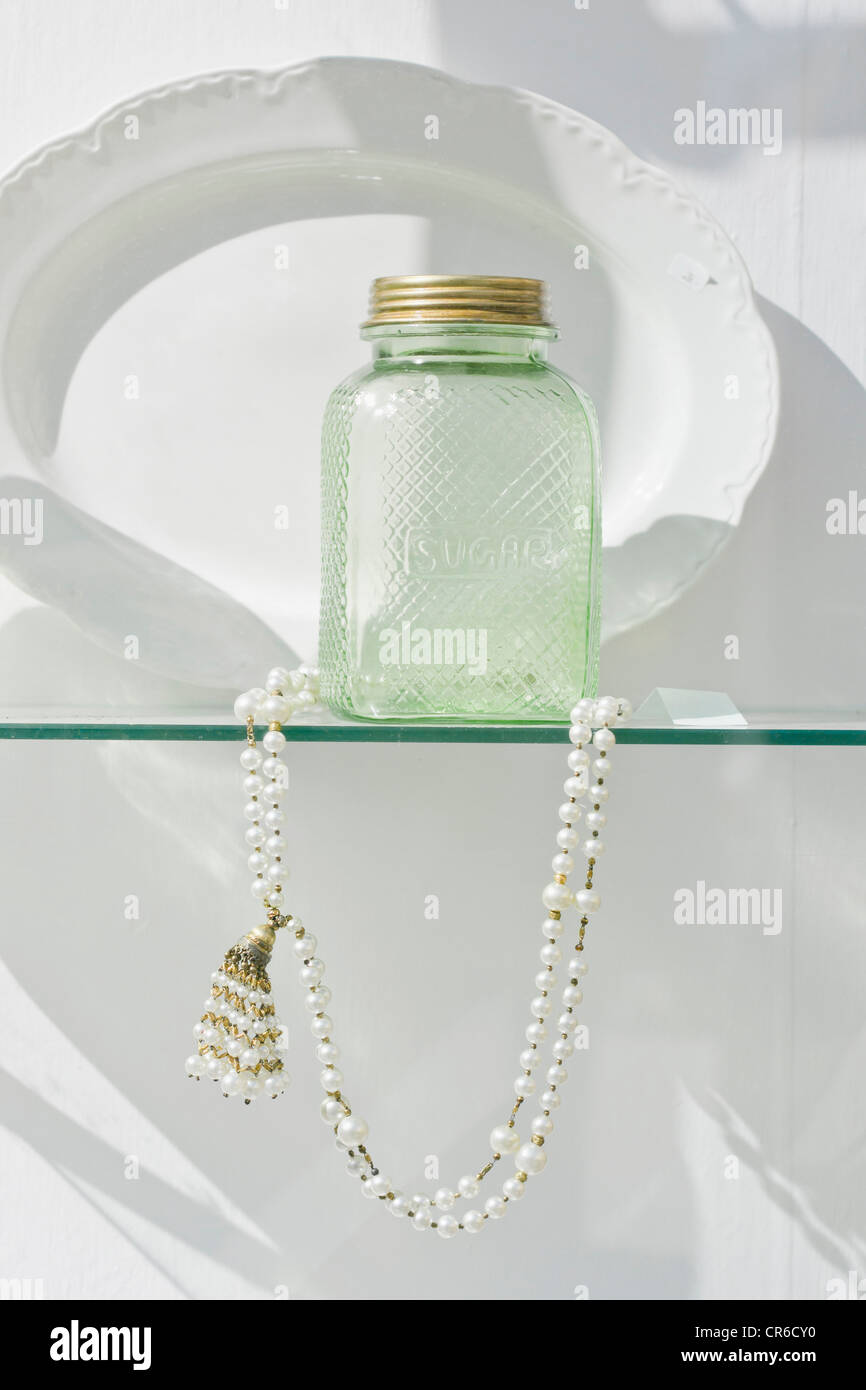 Deutschland, Bayern, München, alte Zucker Flasche mit Perlenkette hinter Schaufenster Stockfoto