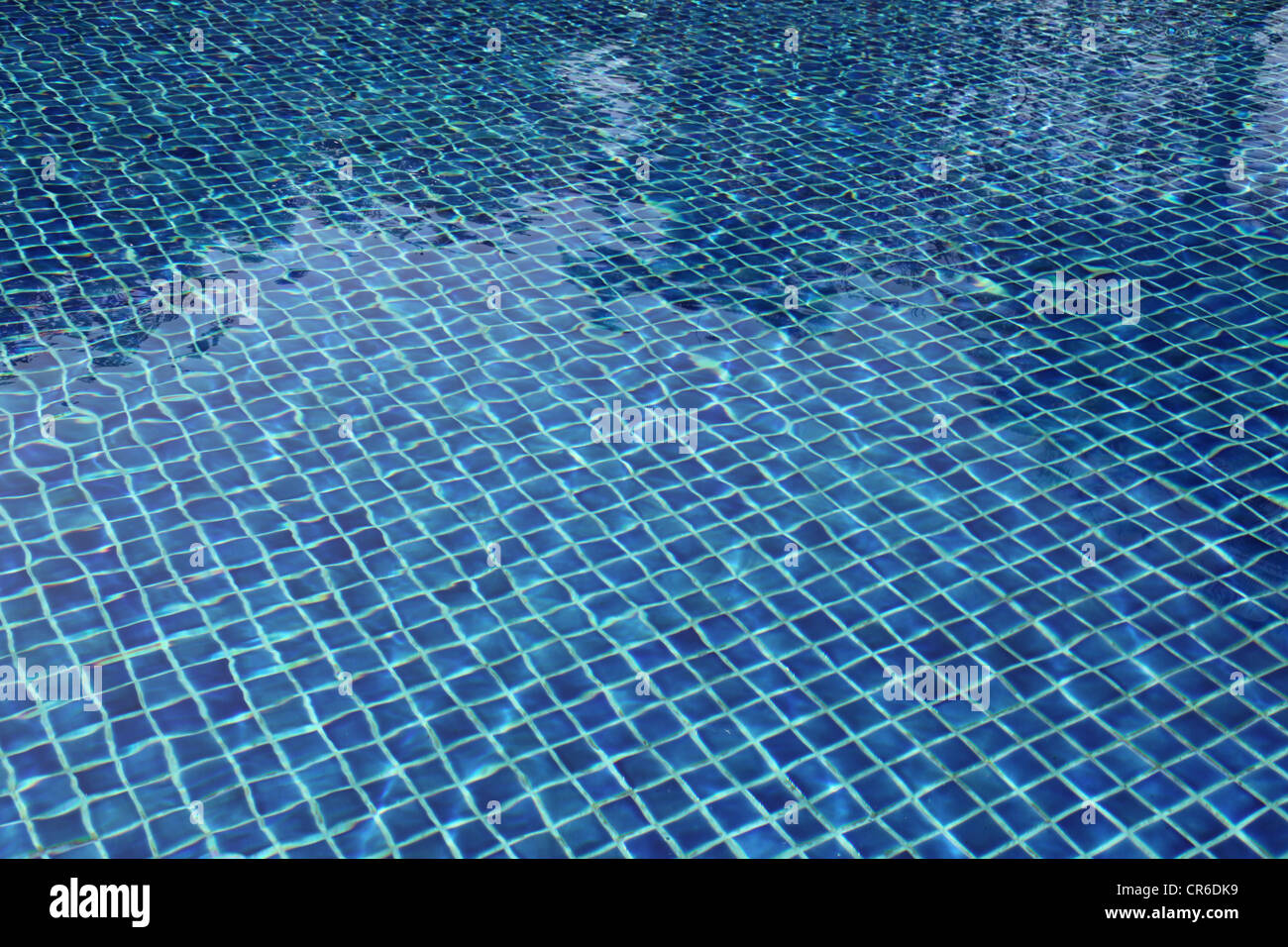 Es ist ein Foto von dem Wasser eines Schwimmbades mit blauen Kacheln auf dem Boden des Beckens. Es ist sonnig und frischer Optik. Tag Stockfoto