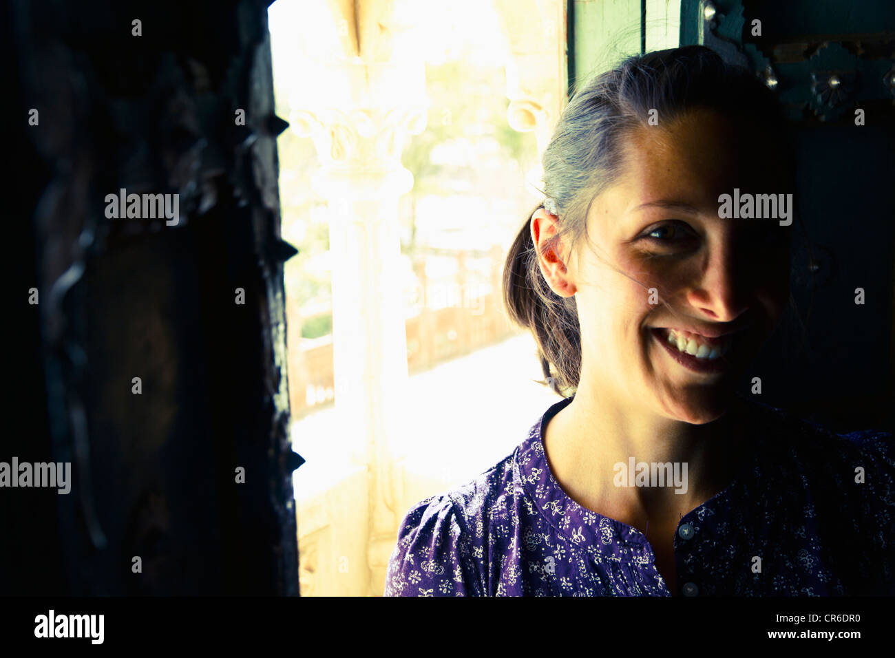 Indien, Rajasthan, Jodhpur, junge Frau, die alten Fenster in Jodhpur Fort stand lächelnd Stockfoto
