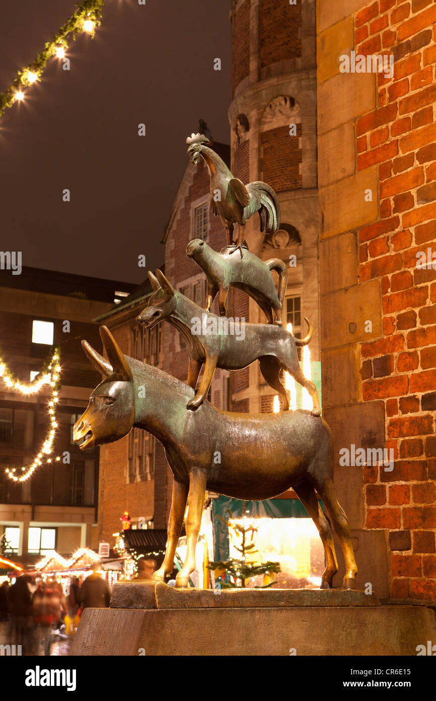 Deutschland, Bremen, Statue der Bremer City Minstrels vor Weihnachtsmarkt in der Nacht Stockfoto