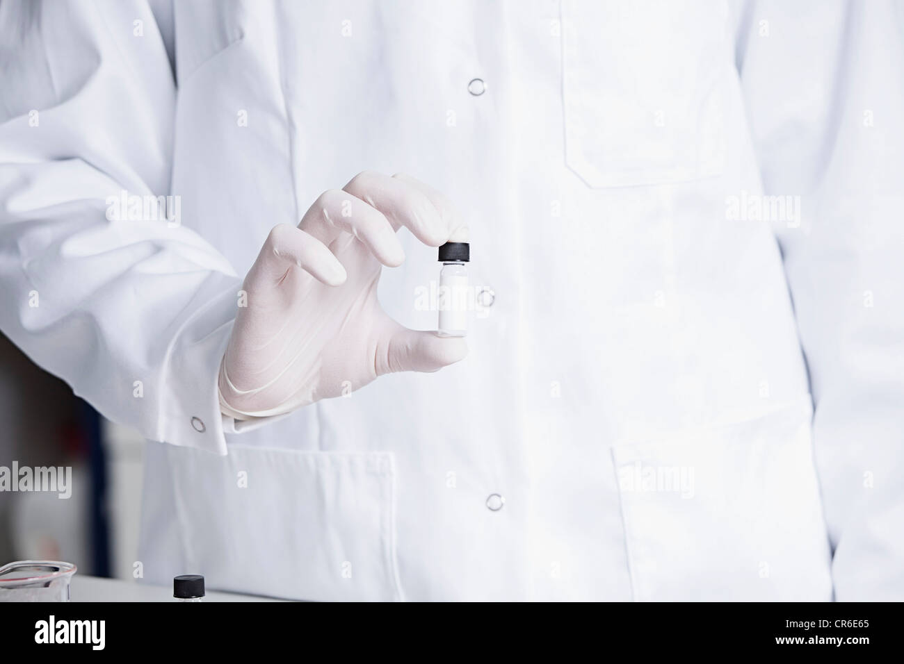 Deutschland, Bayern, München, Wissenschaftler halten Ampulle für die medizinische Forschung im Labor Stockfoto