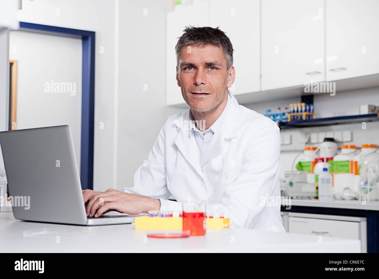 Deutschland, Bayern, München, Wissenschaftler mit Laptop im Labor, Porträt Stockfoto