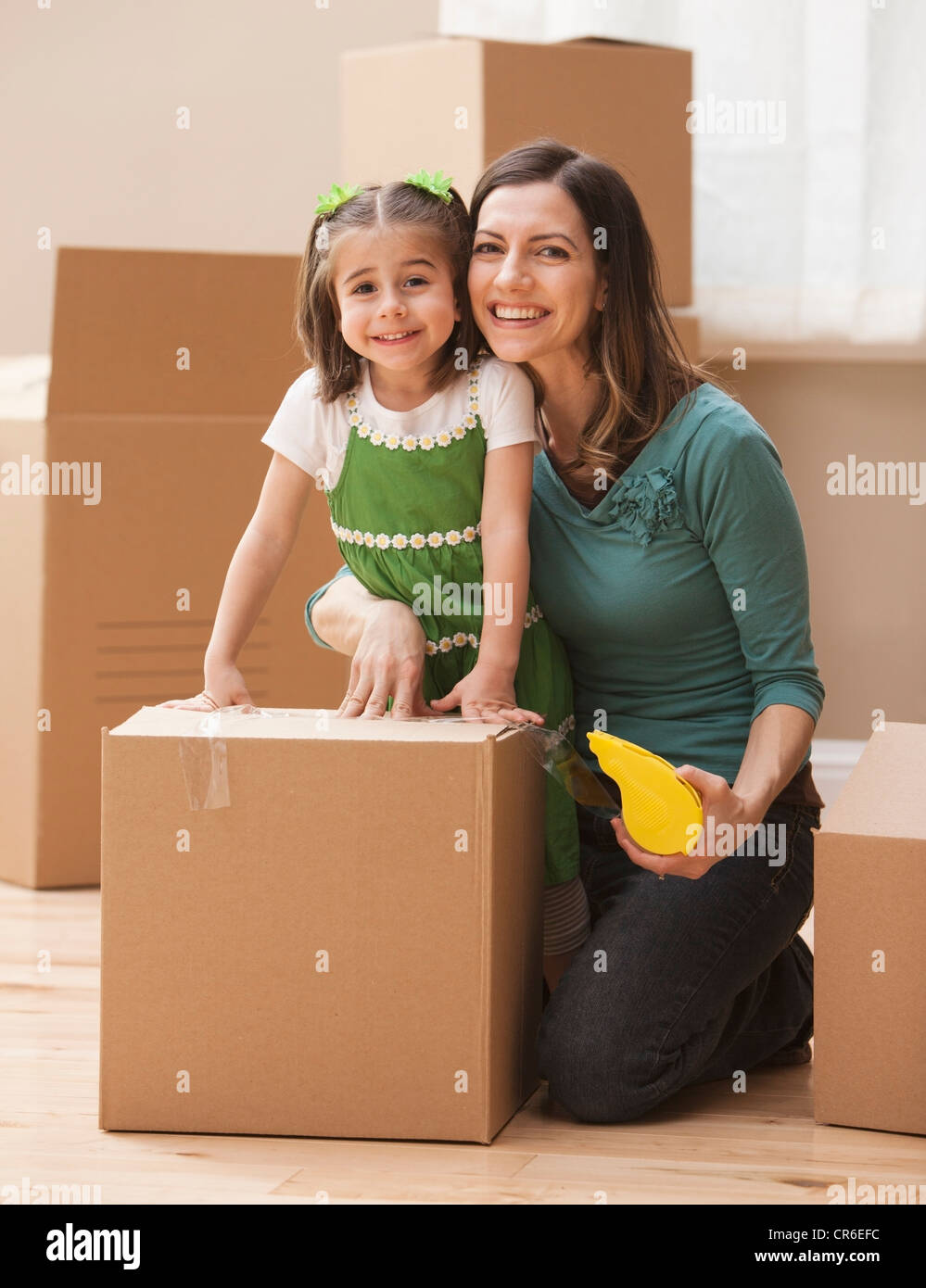Porträt der Mutter mit Tochter (4-5) umgeben von Kartons Stockfoto