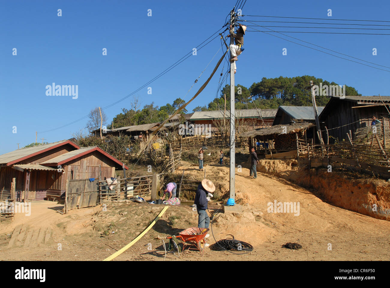 Laos, Hmong Dorf Nam Kha, Dorf Elektrifizierung von Lao-deutsche Firma Sunlabob und NRO, die Arbeiter tun Verkabelung in Power Pole für einen Weg - Gott net im Dorf, die Stromversorgung erfolgt von kleinen Wasserkraftanlagen Turbine produziert Stockfoto