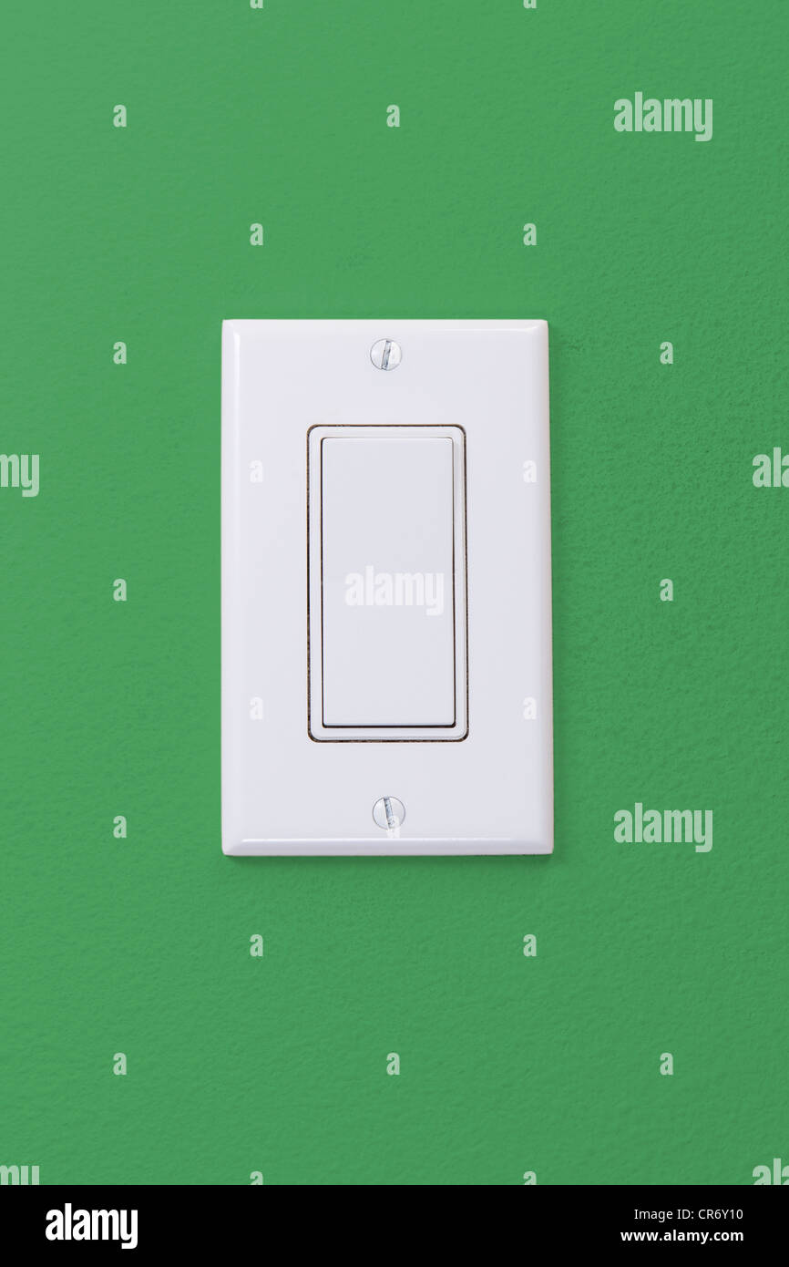Elektrische weiße Licht Wippschalter auf grüne Wand Stockfoto