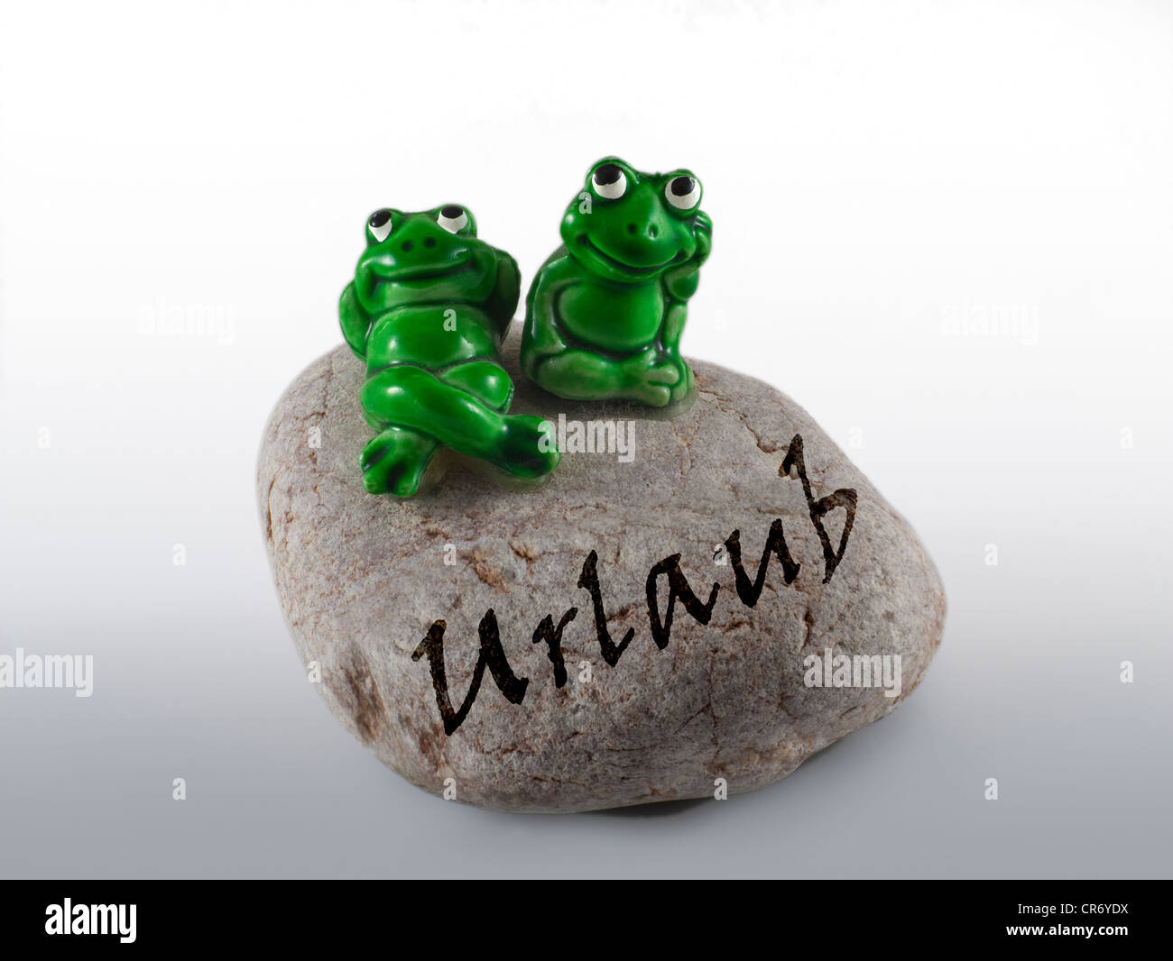 Frosch Figuren auf einem Stein mit der Aufschrift Urlaub, Deutsch für den Urlaub Stockfoto