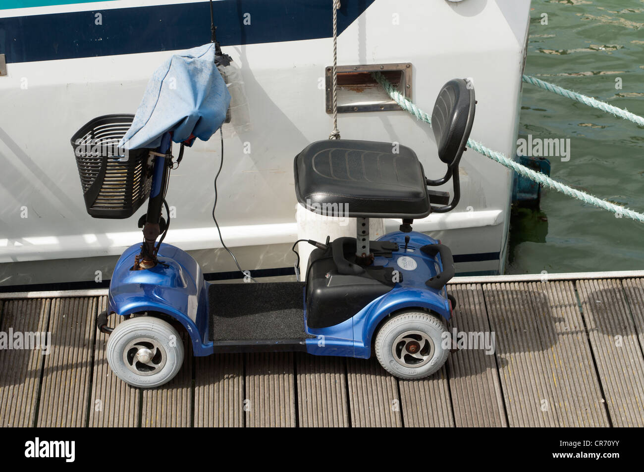 Eine stationäre Mobilität vier Radfahrzeug parkte vor einem festgemachten Boot bei Ramsgate Royal Harbour Marina Kent UK Stockfoto