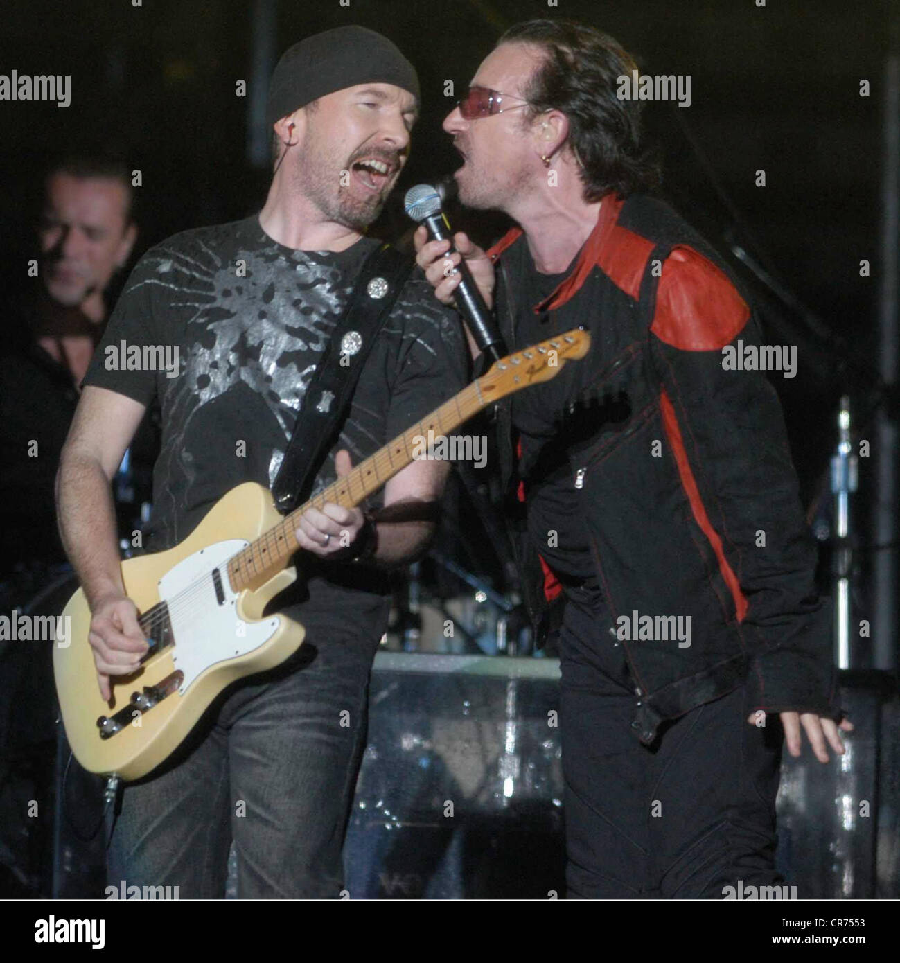 U2, irischer Rockband, Frontmann Bono Vox singt im Regen, halbe Länge, mit Gitarrist The Edge, Olympiastadion, München, Deutschland, 2.8.2005, Stockfoto