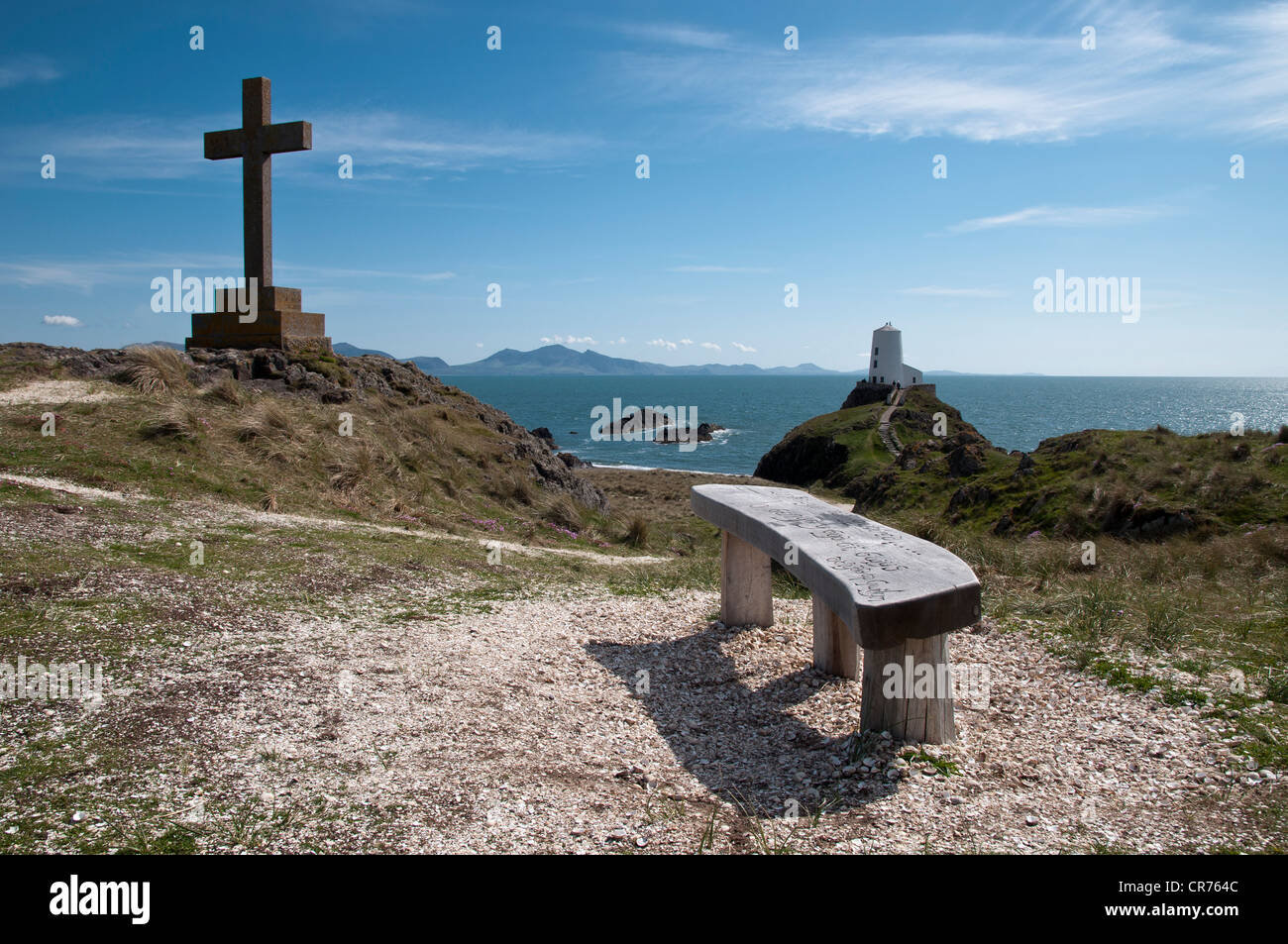 Geschnitzte Holzsitz mit Blick auf den alten Leuchtturm und Lleyn-Halbinsel auf Llanddwyn Insel Anglesey North Wales Stockfoto