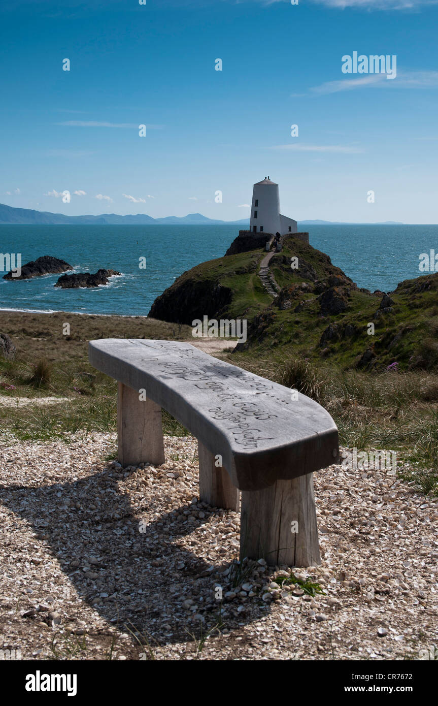 Geschnitzte Holzsitz mit Blick auf den alten Leuchtturm und Lleyn-Halbinsel auf Llanddwyn Insel Anglesey North Wales Stockfoto