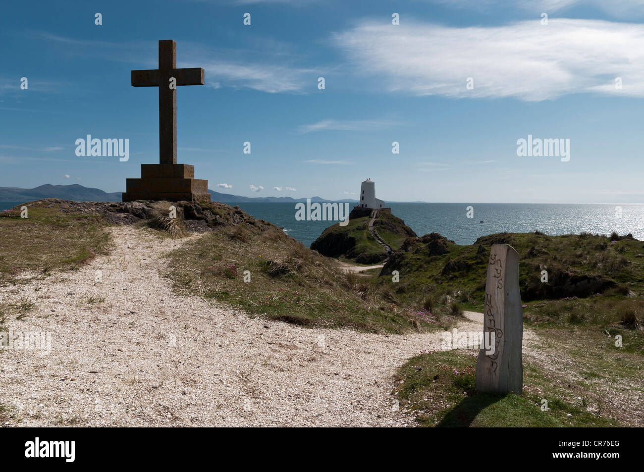 Aus Holz geschnitzte Marker Post mit Blick auf den alten Leuchtturm und Lleyn-Halbinsel auf Llanddwyn Insel Anglesey North Wales Stockfoto