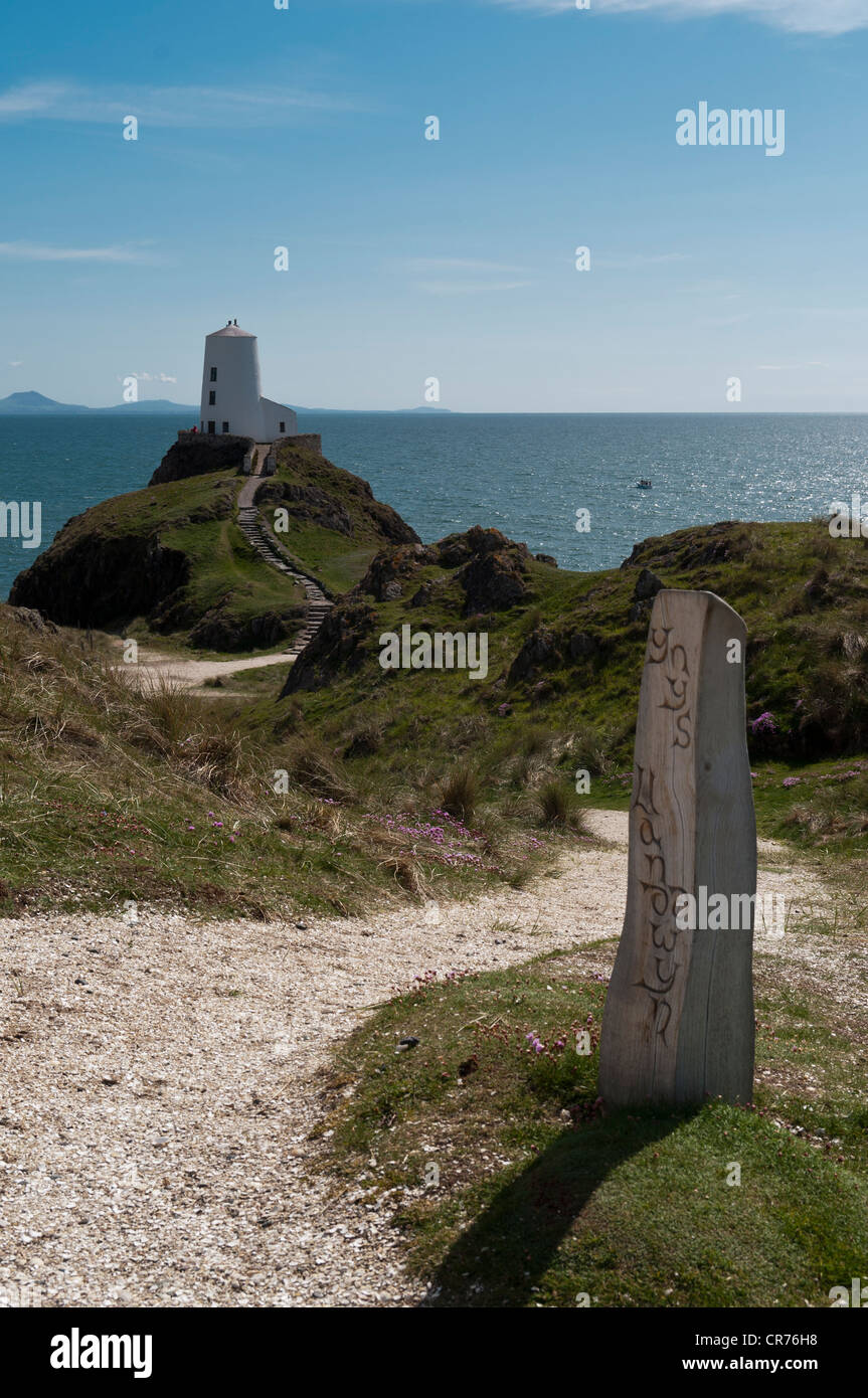 Aus Holz geschnitzte Marker Post mit Blick auf den alten Leuchtturm und Lleyn-Halbinsel auf Llanddwyn Insel Anglesey North Wales Stockfoto