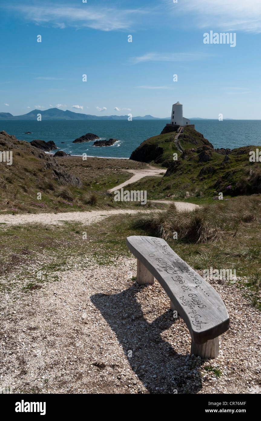 Geschnitzte Holzsitz mit Blick auf den alten Leuchtturm und Lleyn-Halbinsel auf Llanddwyn Insel Anglesey North Wales Stockfoto