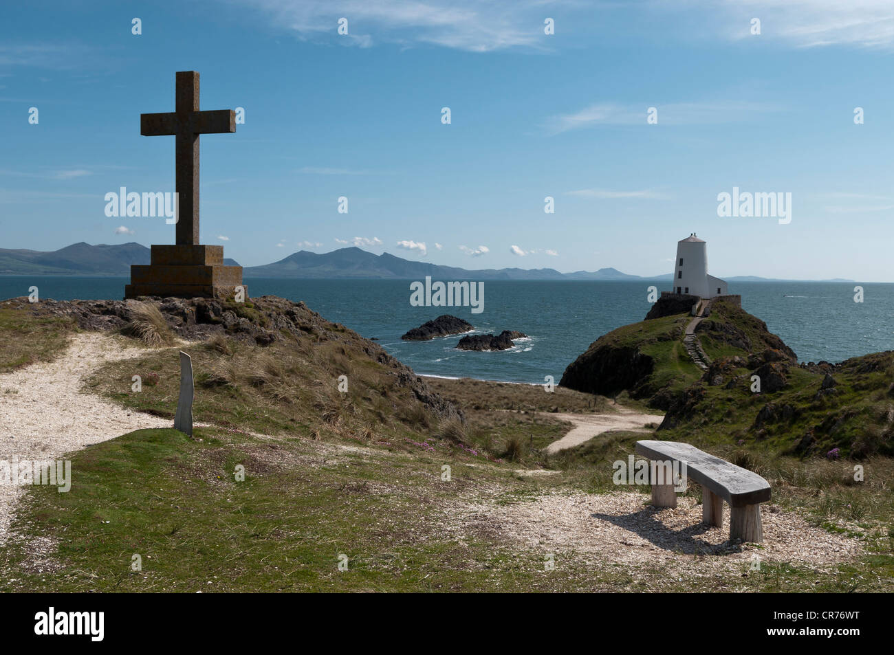 Geschnitzte Holzsitz mit Blick auf den alten Leuchtturm und Lleyn-Halbinsel auf Llanddwyn Insel Anglesey North Wales Stockfoto