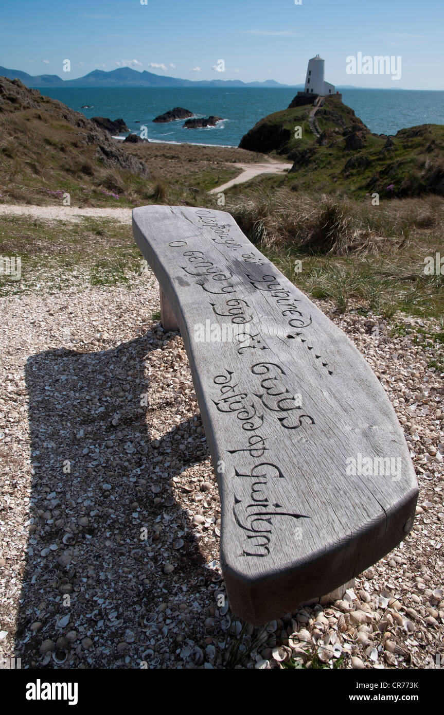 Geschnitzte Holzsitz mit Blick auf den alten Leuchtturm und Lleyn-Halbinsel auf Llanddwyn Insel Anglesey North Wales Stockfoto