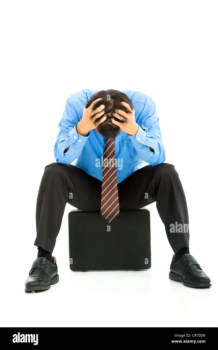 Geschäftsmann, sitzen auf Aktenkoffer mit Kopfschmerzen Stockfoto