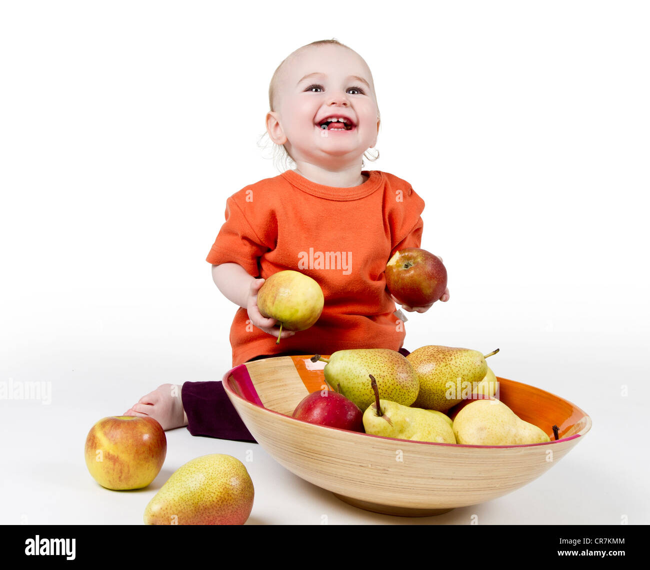 lachendes Baby mit Äpfeln und Birnen, die Verlegung in Schüssel - Studio gedreht Stockfoto