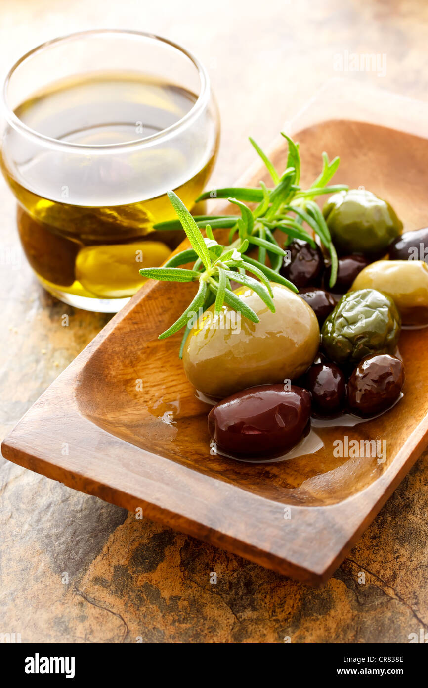 Olivenöl und gemischten Oliven mit frischem Rosmarin Stockfoto