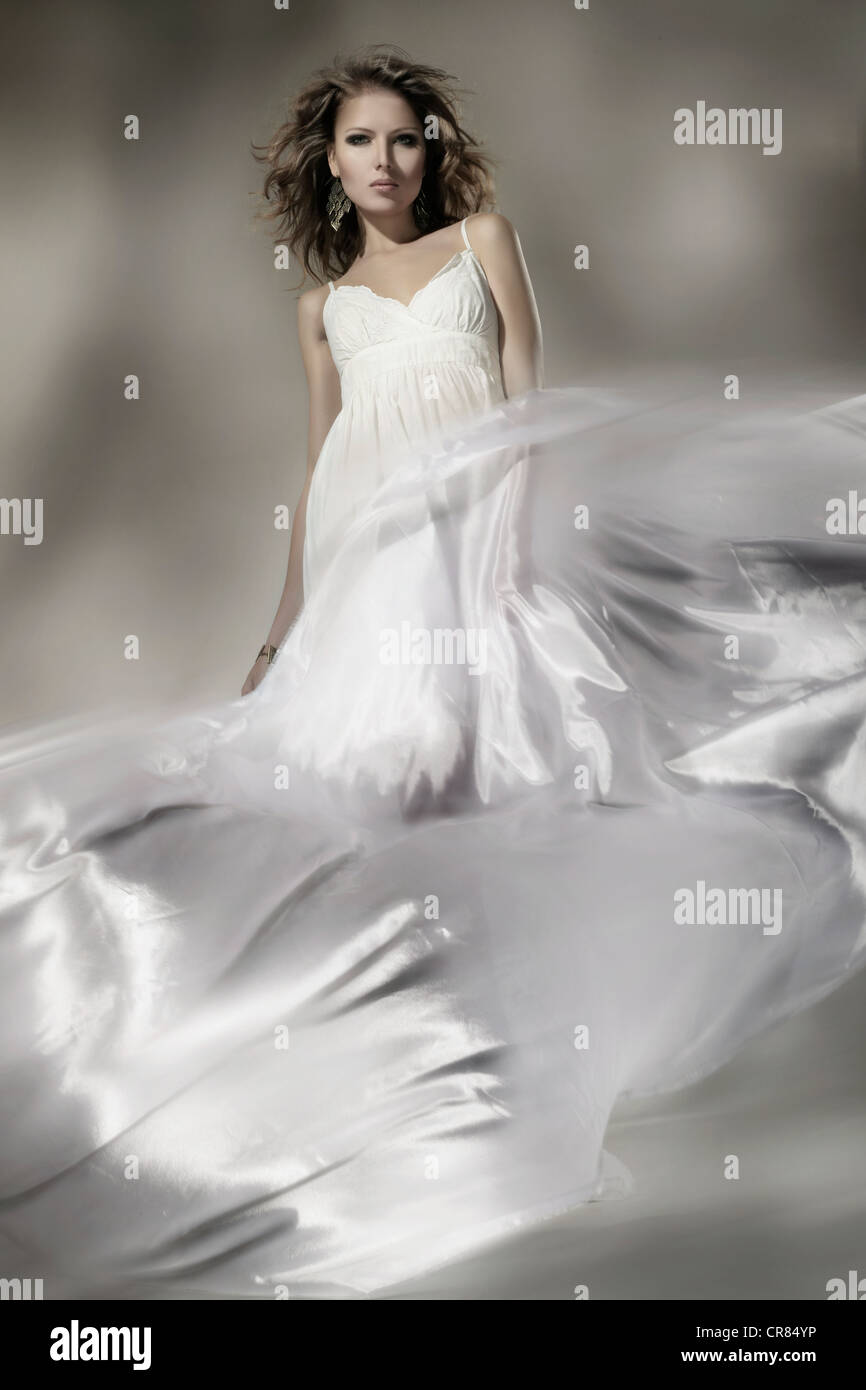 Junge Frau trägt ein weißes Kleid mit wallenden Stoff, Mode Stockfoto