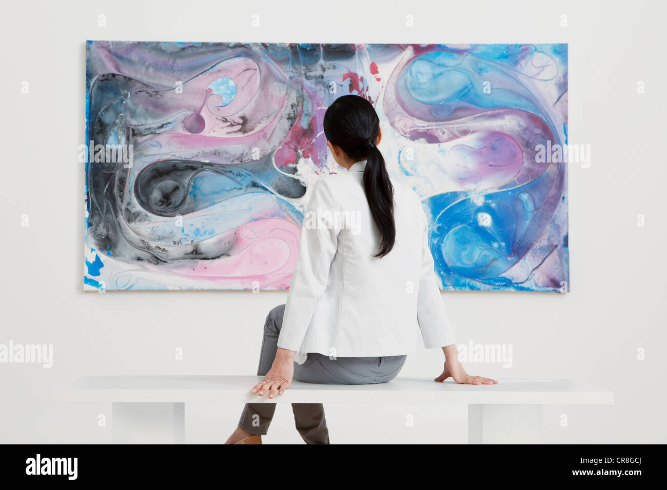 Junge Frau, die Öl-Malerei in der Galerie zu betrachten Stockfoto