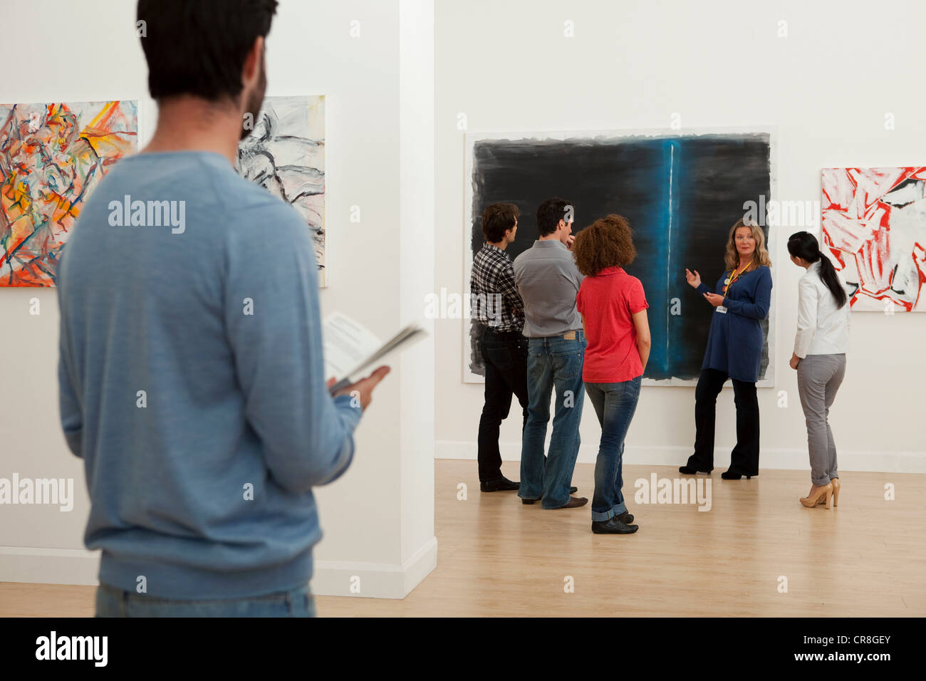 Männer und Frauen, die zuhören, um in der Art Gallery guide Stockfoto