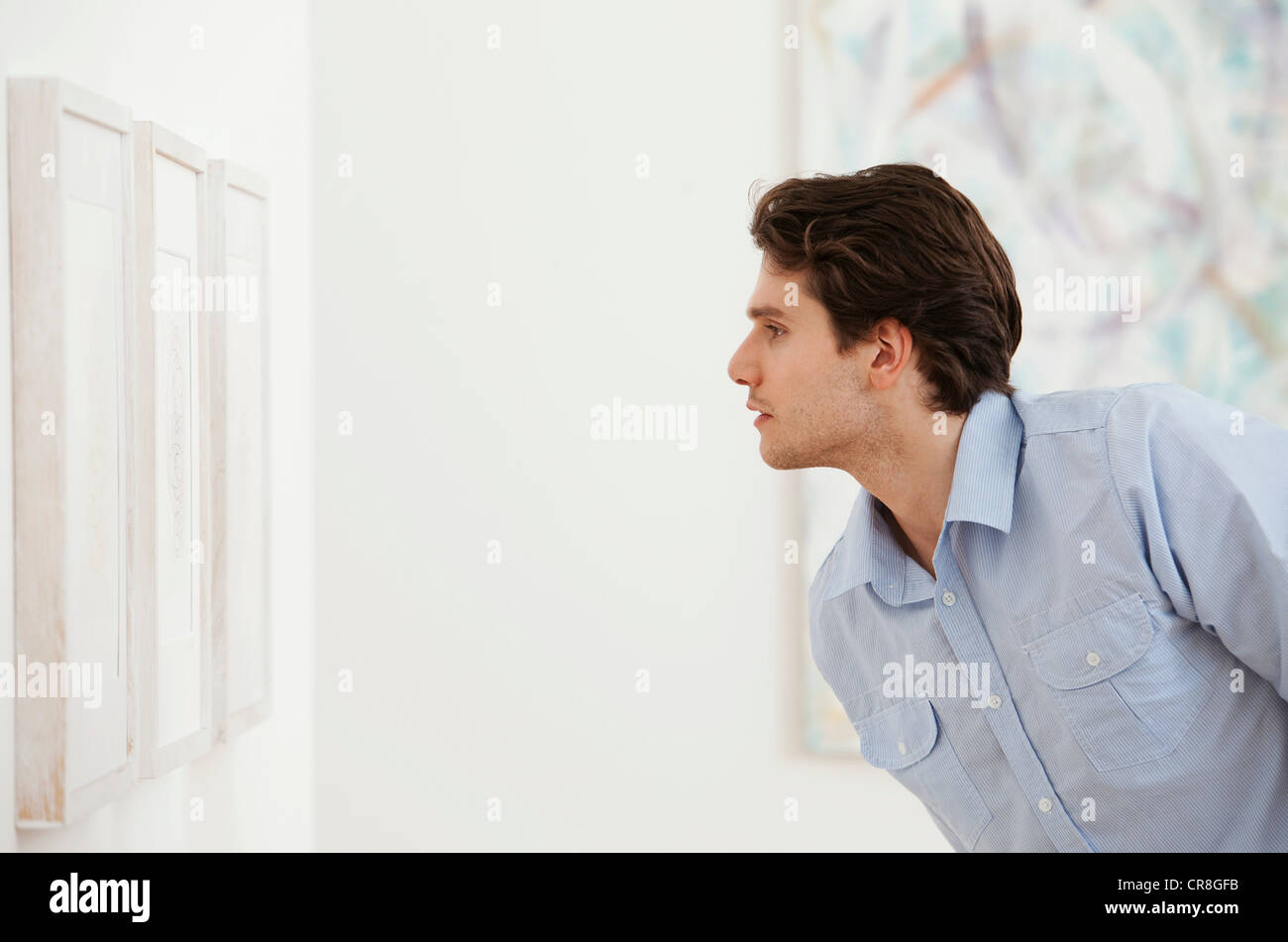 Junger Mann mit Blick auf Bild in Kunstgalerie Stockfoto