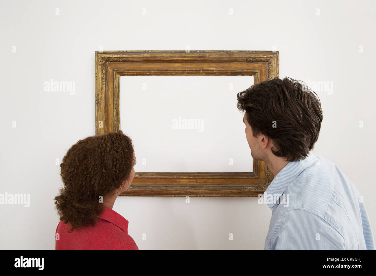 Junges Paar mit Blick auf leere Bild im Bilderrahmen Stockfoto