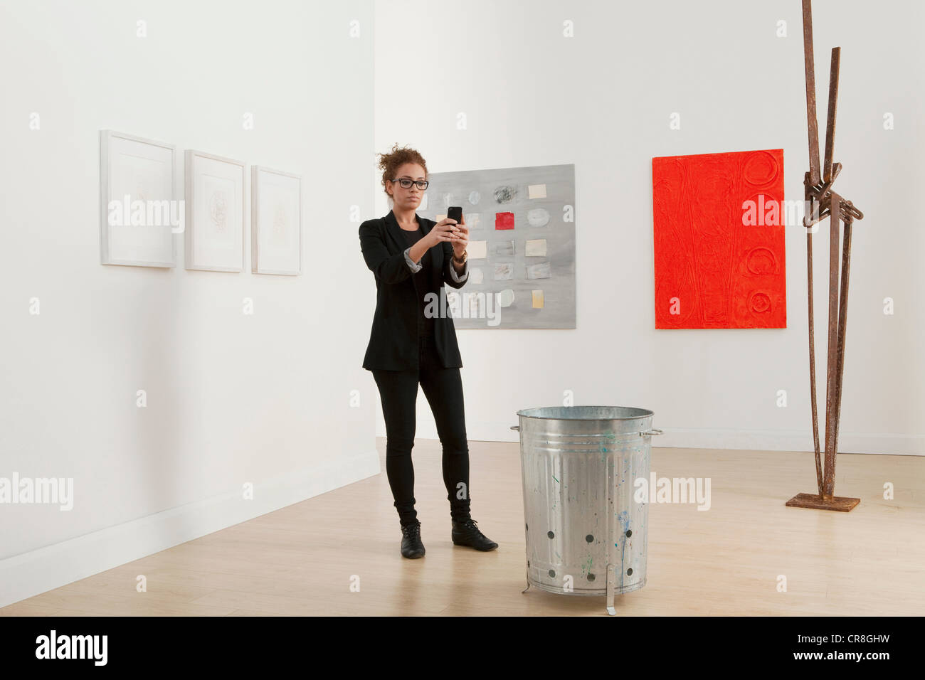 Junge Frau mit Handy Galerie Kunstwerk fotografieren Stockfoto