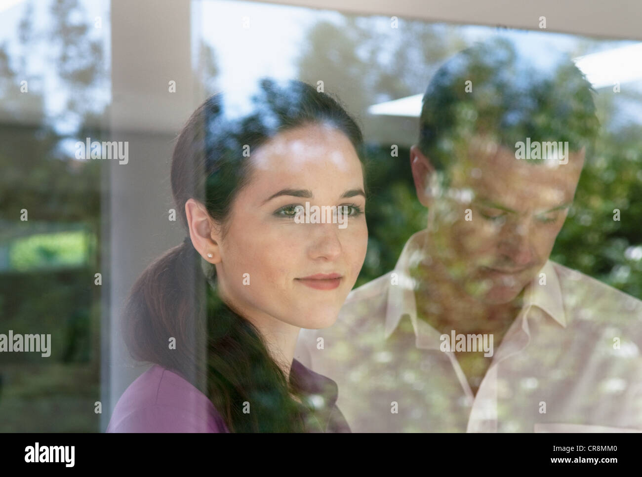 Frau, die durch Fenster, Mann auf der Suche nach unten Stockfoto