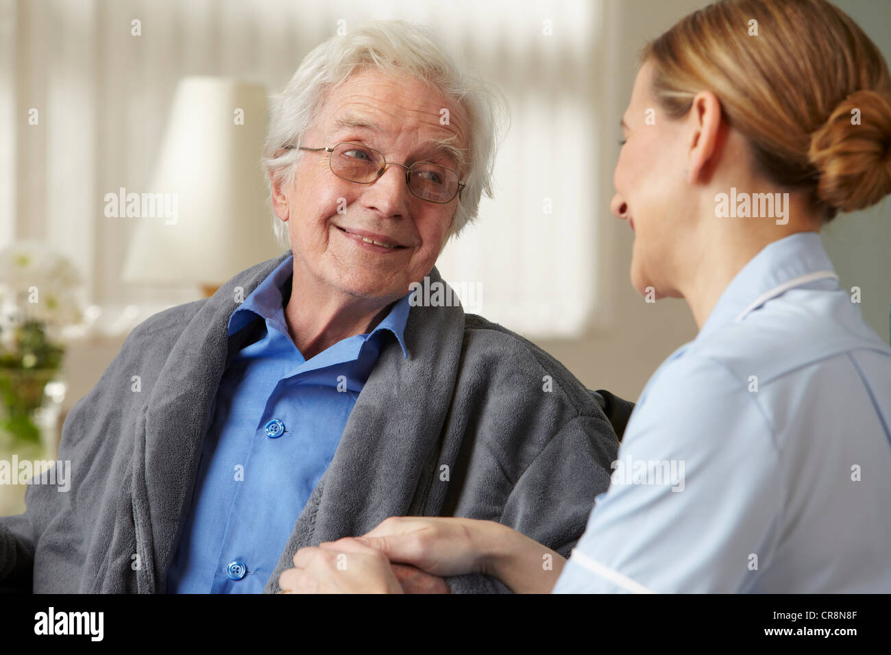 Pfleger berühren Senior mans hand Stockfoto