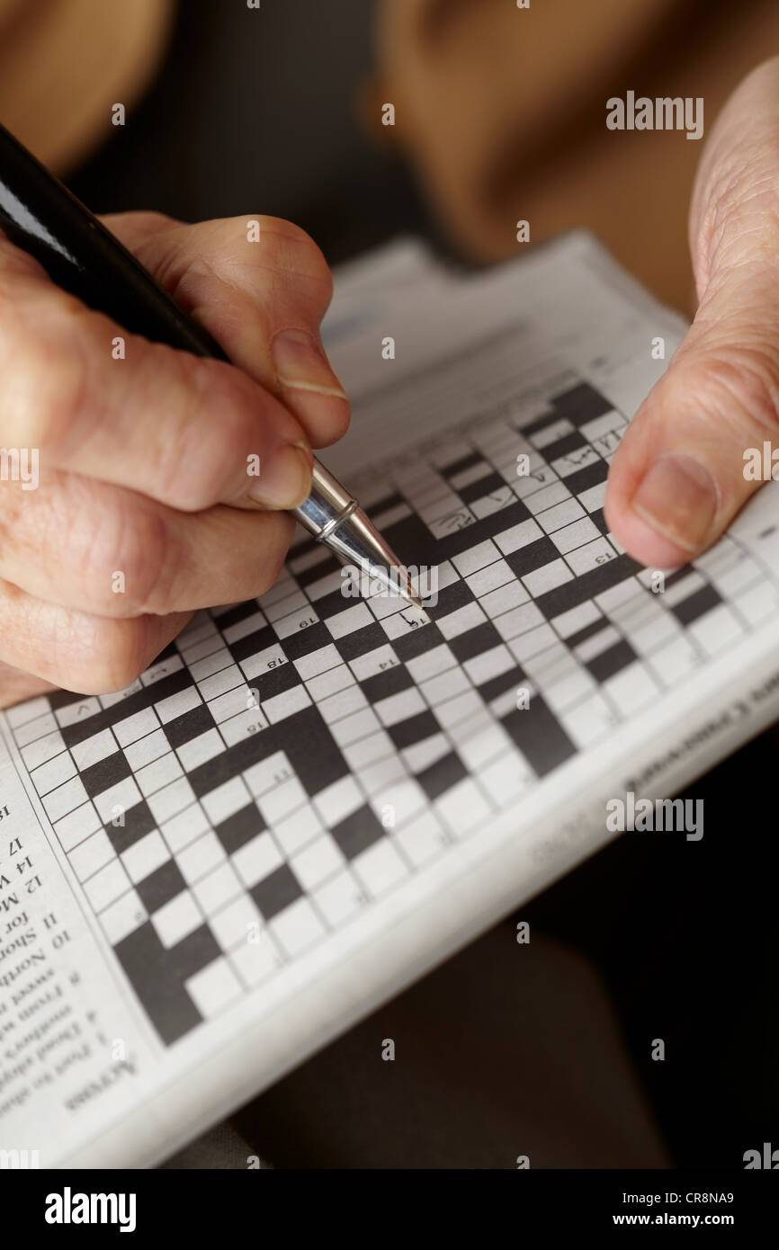 Ältere Frau macht Kreuzworträtsel Stockfoto