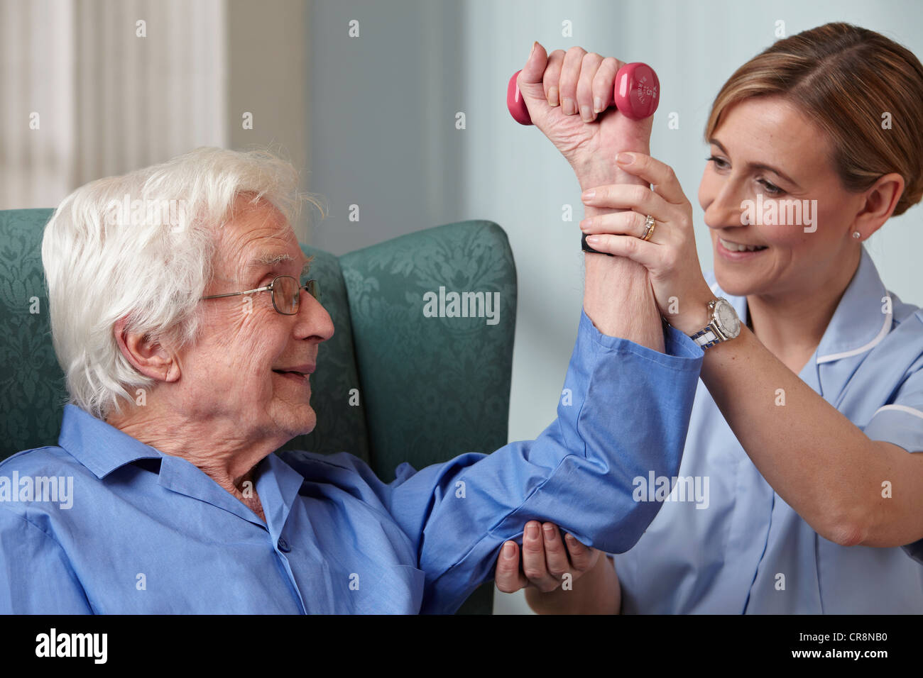 Betreuer, die Unterstützung von älteren Mann mit Hanteln Stockfoto
