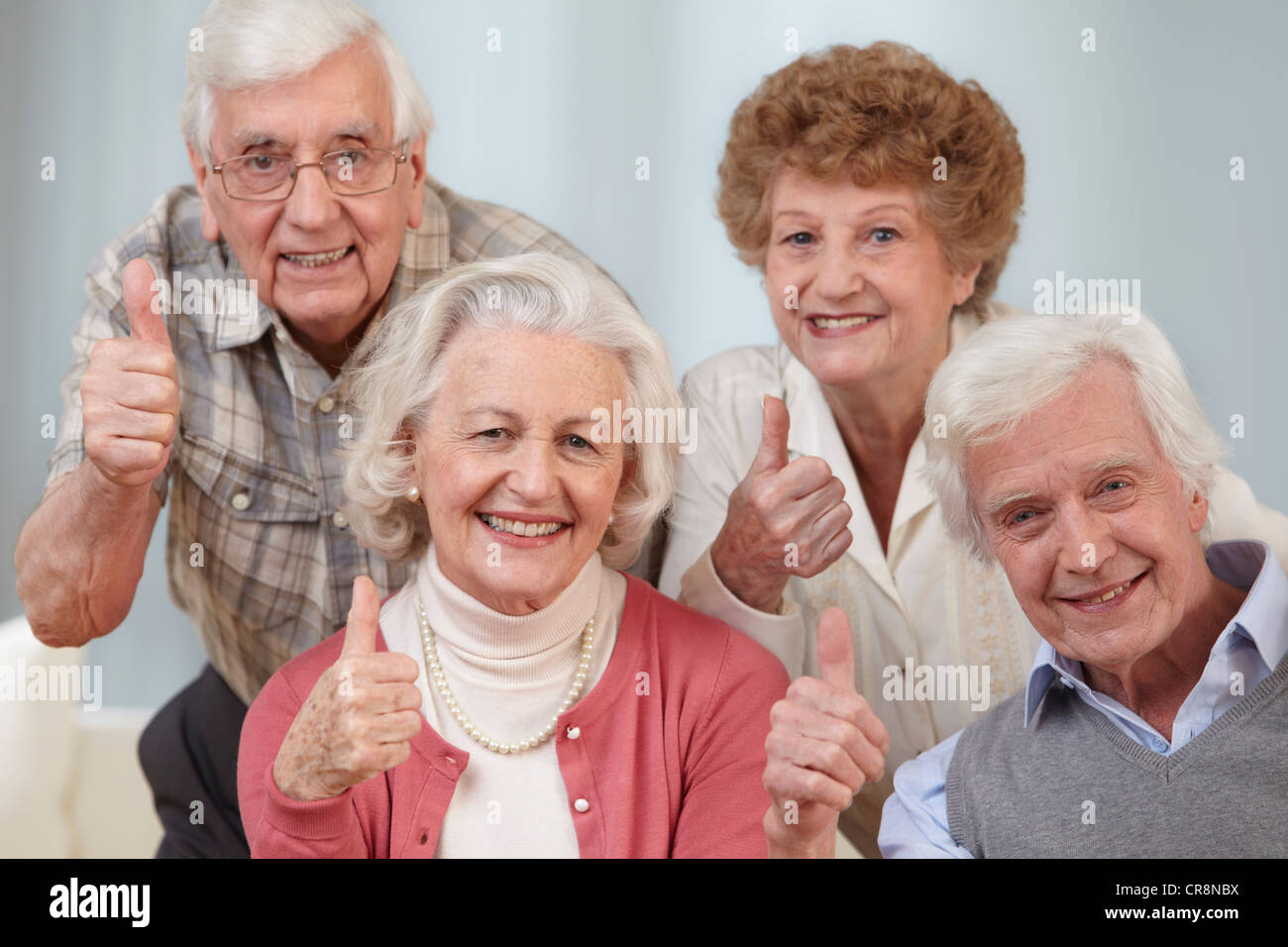 Vier Senioren mit Daumen hoch, Porträt Stockfoto