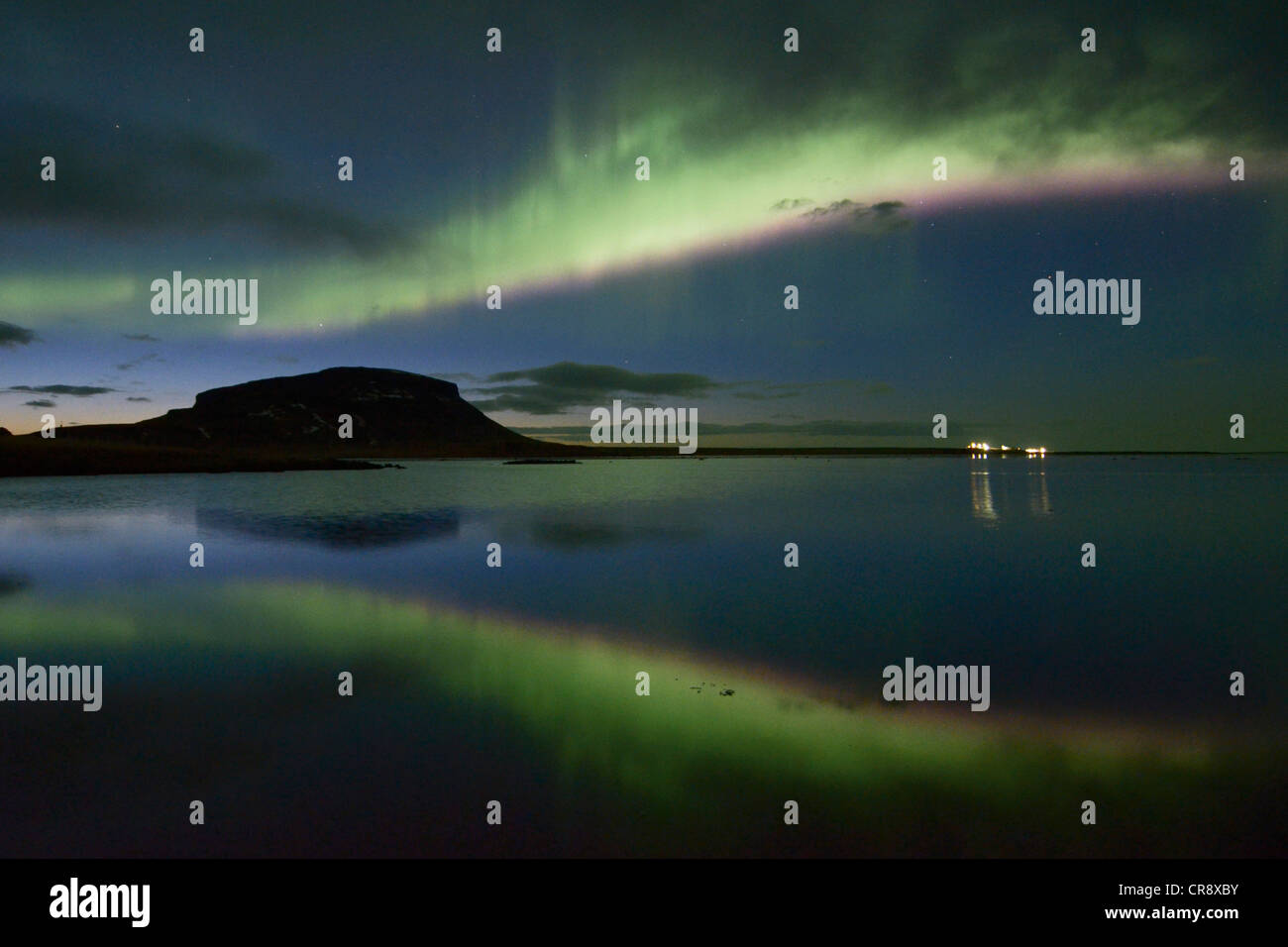 Starke Nordlichter (Aurora Borealis) spiegelt sich in der Abenddämmerung im Fjord über den Mt. Brimlárhoefði in Grundarfjoerður Stockfoto