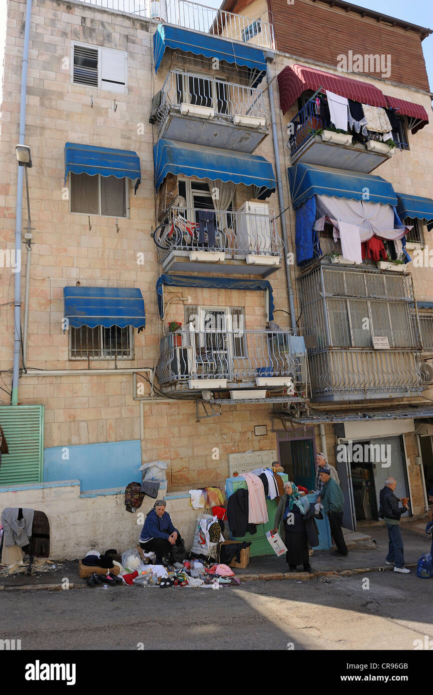 Straßenszene, beherbergt Frau verkaufen Kleidung auf der Straße, wohnen mit Balkon, die verwendet werden, vor dem Mahane Stockfoto
