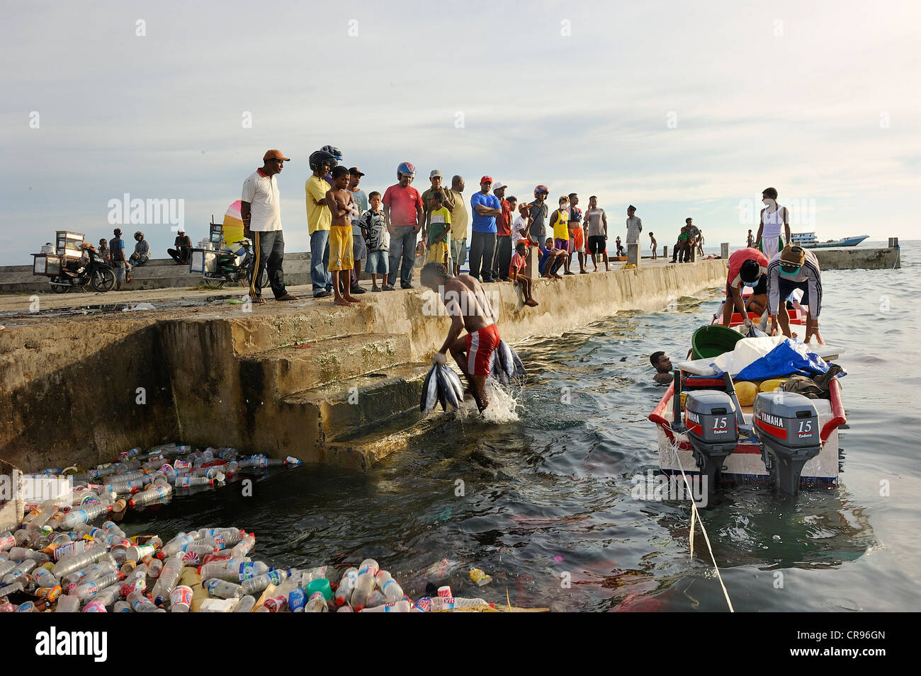 Fischer ihren Fang anlanden nimmt es sich zu den Kaimauern Kunststoff Treibgut an Front, Kota Biak, Biak Insel, Irian Jaya Stockfoto
