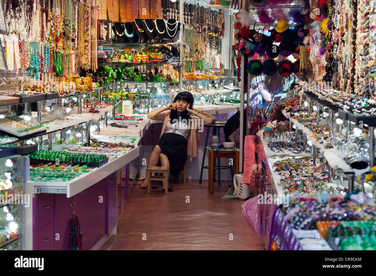 Stall - Keeper im Chat auf Handy in Stanley Market, Hong Kong Stockfoto