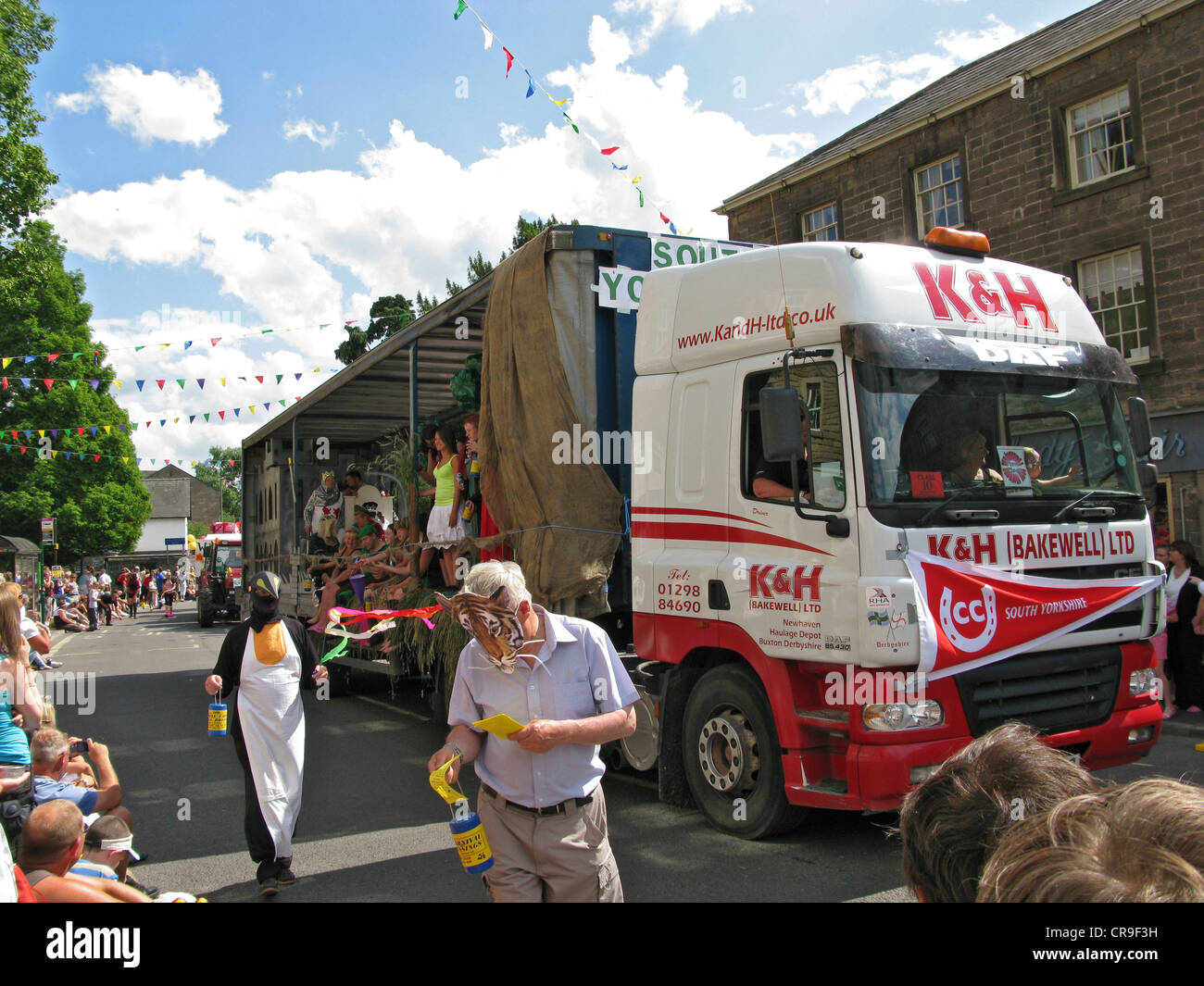 Bakewell Karnevalsumzug in Derbyshire 2009. Menschenmengen säumen die Straße um zu sehen, Schwimmer und Entertainer. Stockfoto