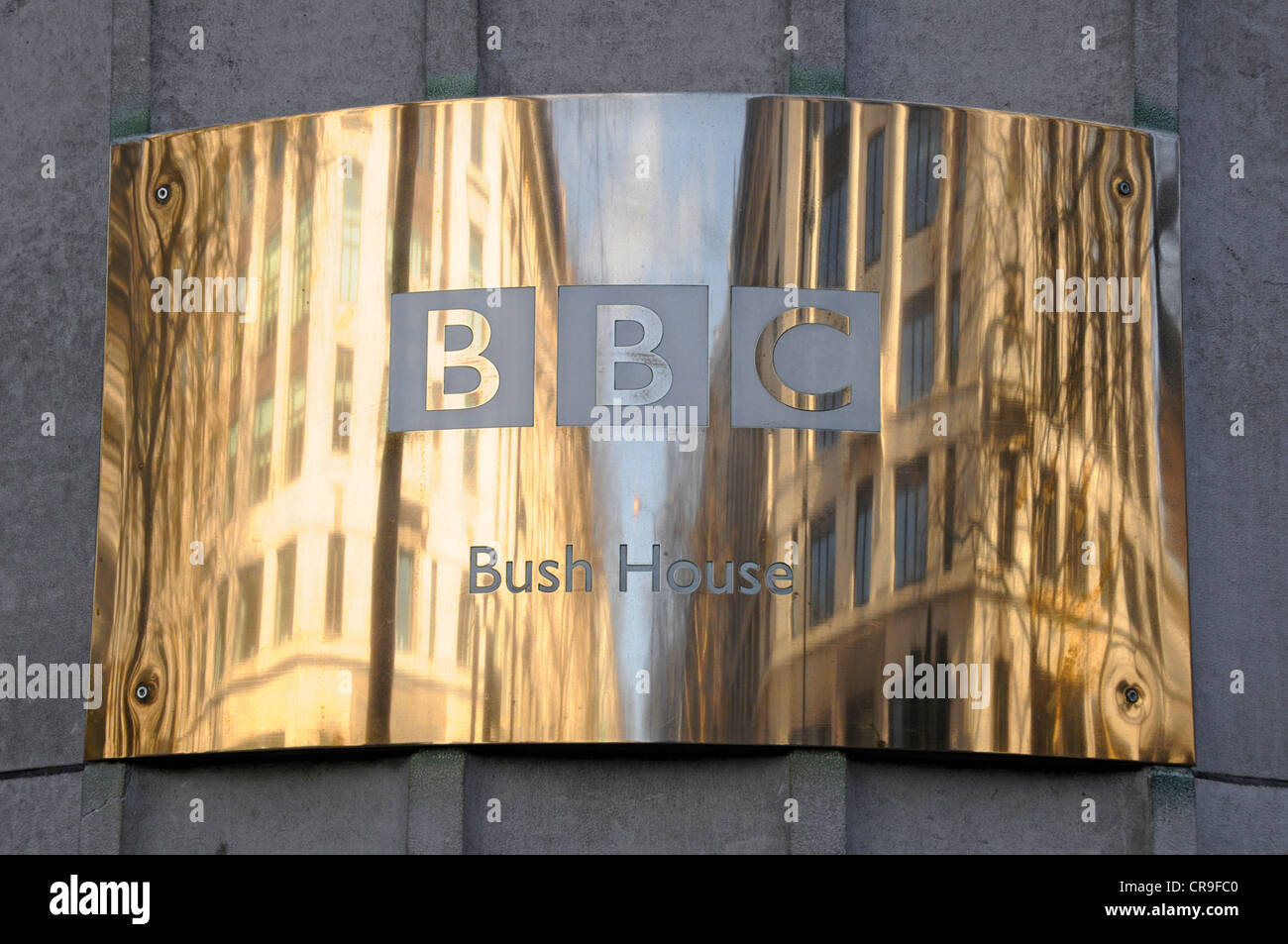 Messing BBC Typenschild & Reflexionen auf gekrümmten Oberfläche außerhalb der Bush House Hauptquartier für BBC World Service Aldwych London England Großbritannien Stockfoto